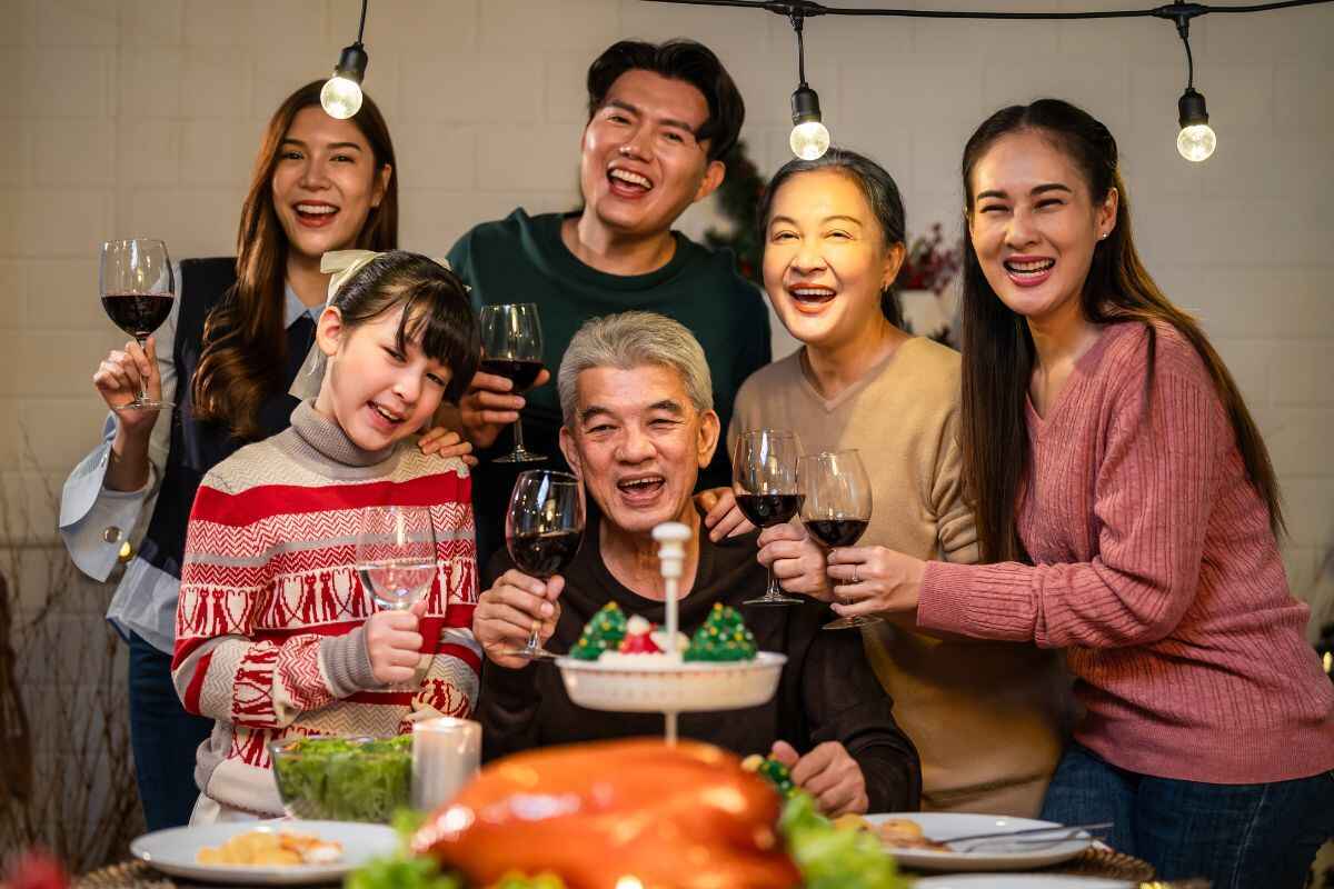 family celebrating christmas party at home Happy family celebrating Christmas dinner together with wine and festive food.