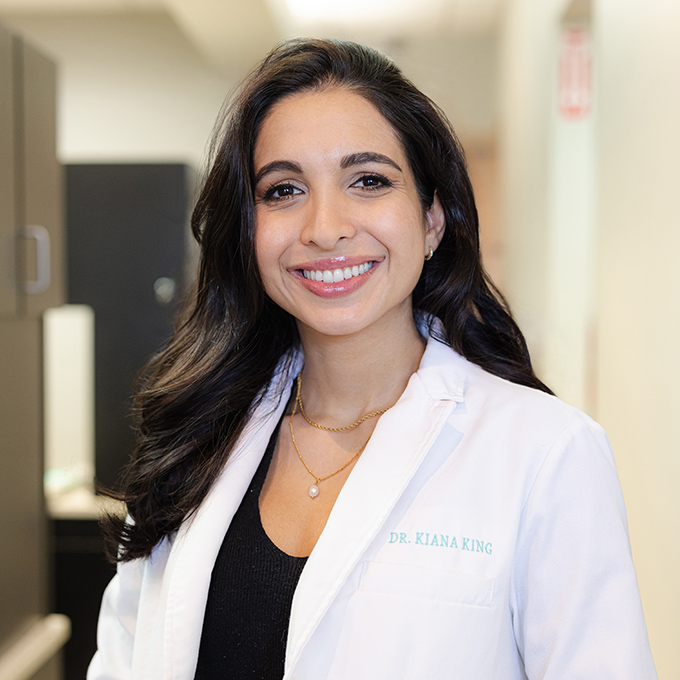 img-dr-Bright Professional headshot of Dr. Kiana King in white lab coat, smiling in clinical office setting.
