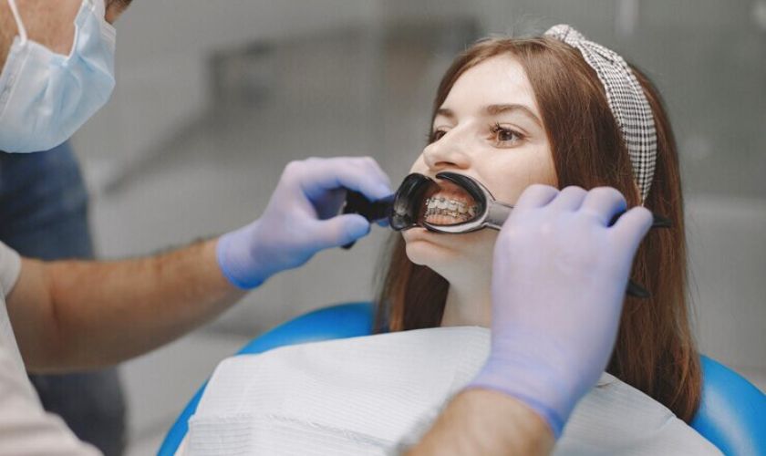 Orthodontic Treatment in Spring, TX – BLVD Dentistry Dental professional examining patient's teeth with intraoral mirror in clinical setting.