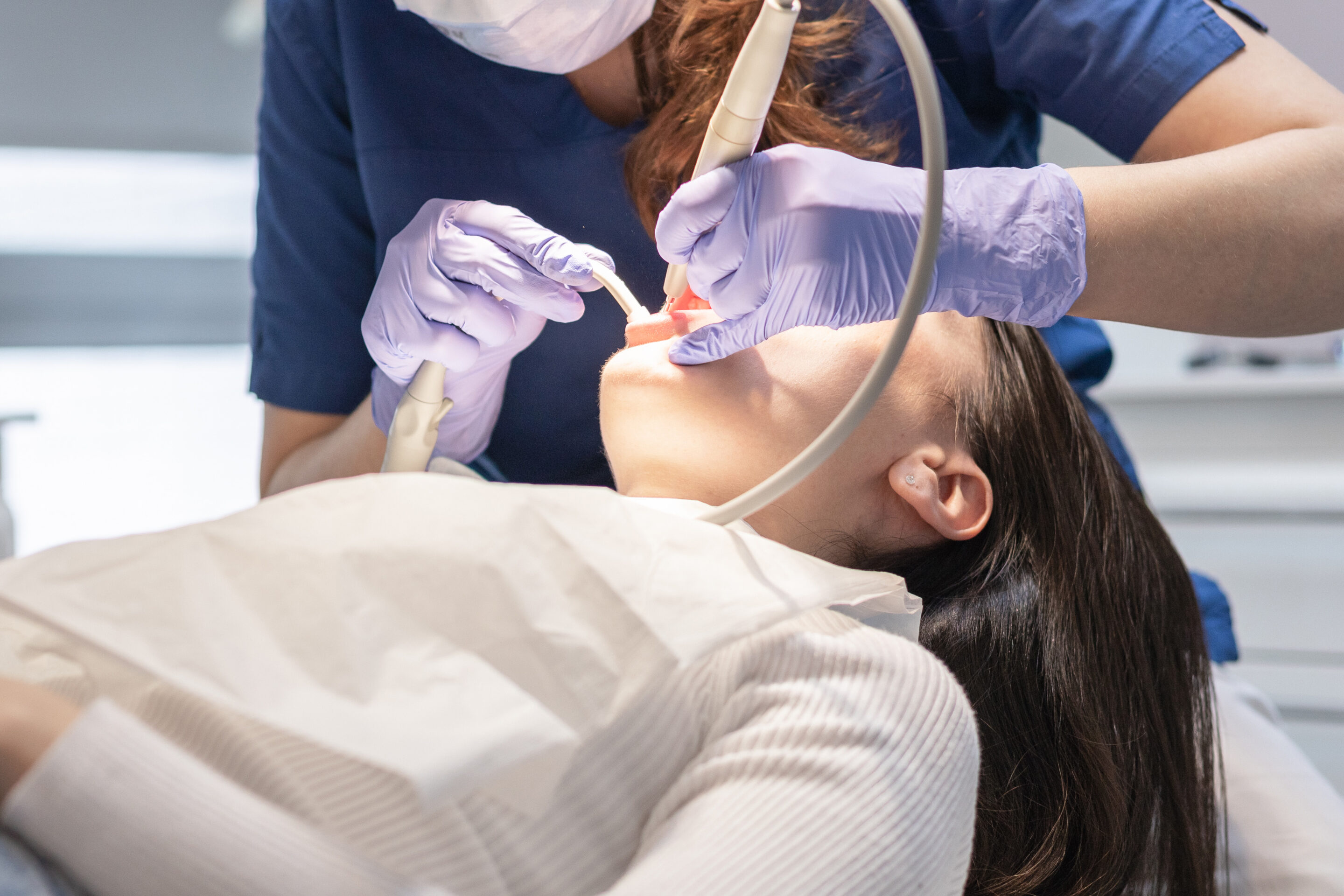 The dentist cleans the patient's mouth. Sedation Dentist Houston