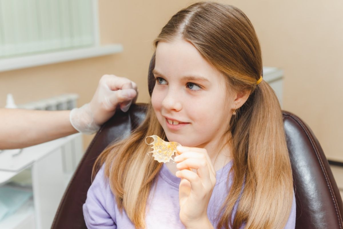 child holding retainer for orthodontic treatment child holding retainer for orthodontic treatment