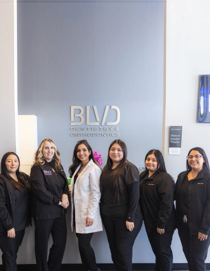 img-blvd-dentistry—orthodontics3 Professional dental team of six women posing together in front of BVD Dentistry & Orthodontics office signage.