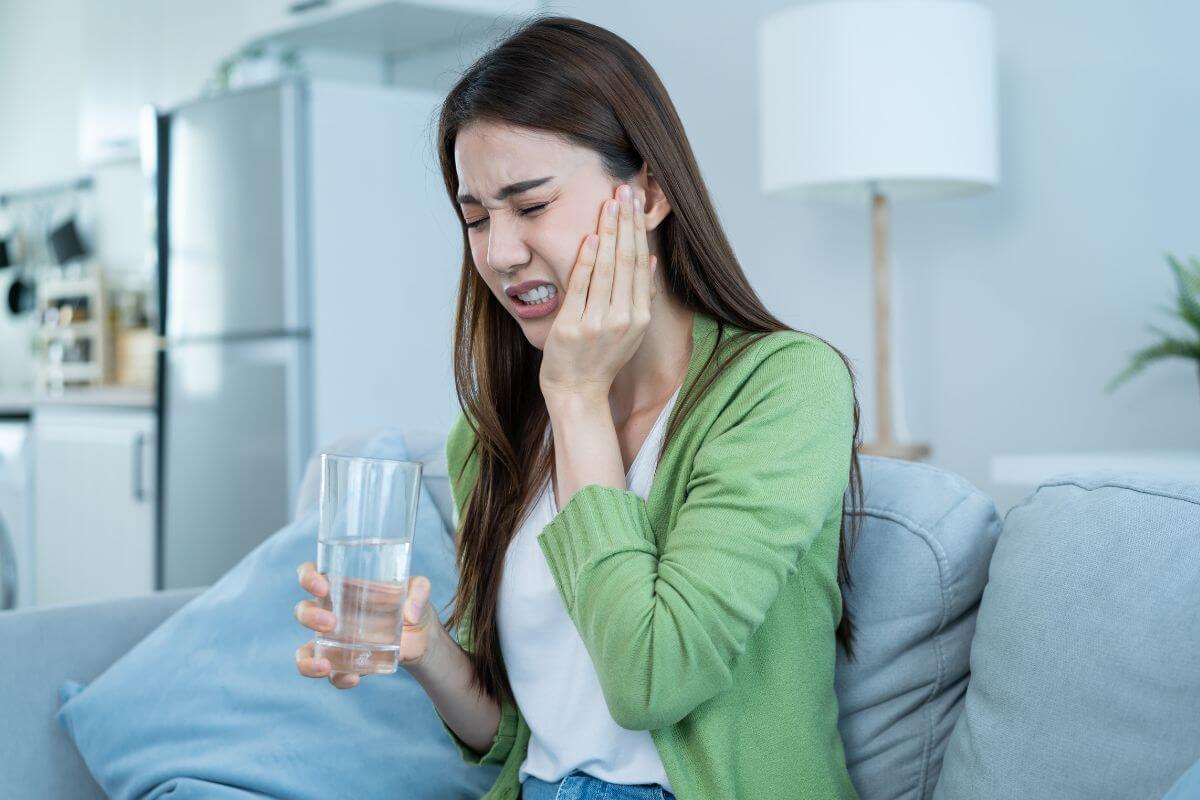 Woman feeling sensitivity when drinking water Woman feeling sensitivity when drinking water