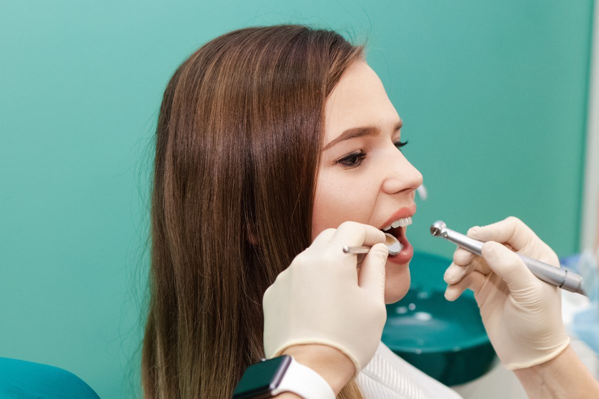 Austin dentist discussing a personalized dental treatment plan with a patient Dentist examining patient's teeth during routine dental examination and care.