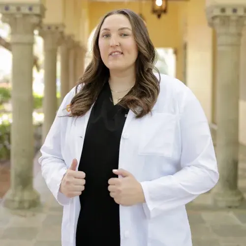 images-dr-caitlyn-cunyus Dr. Caitlyn Cunyus, DDS, poses in professional white coat at Fort Worth dental practice.